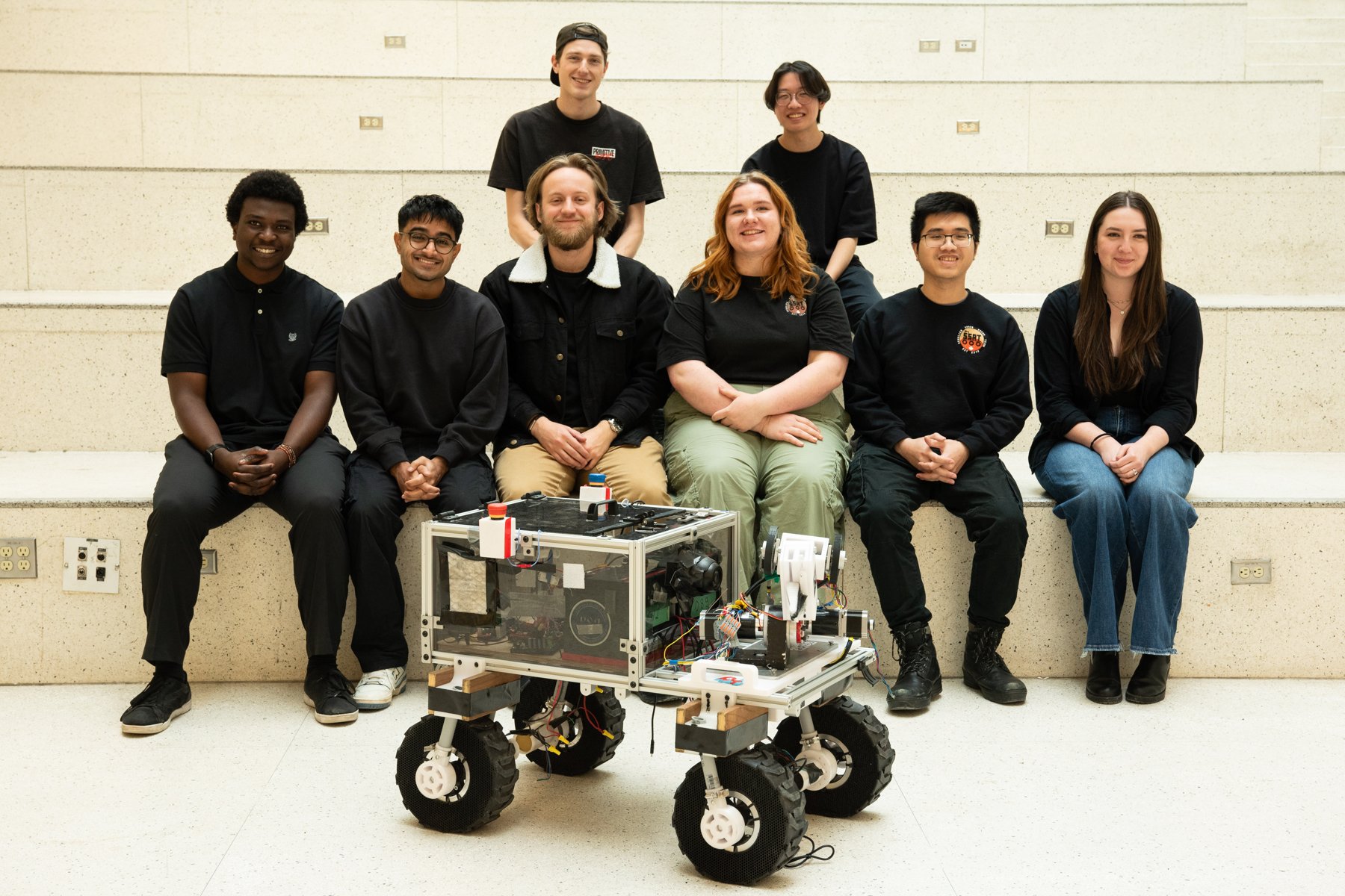 SSRT members seated behind the rover